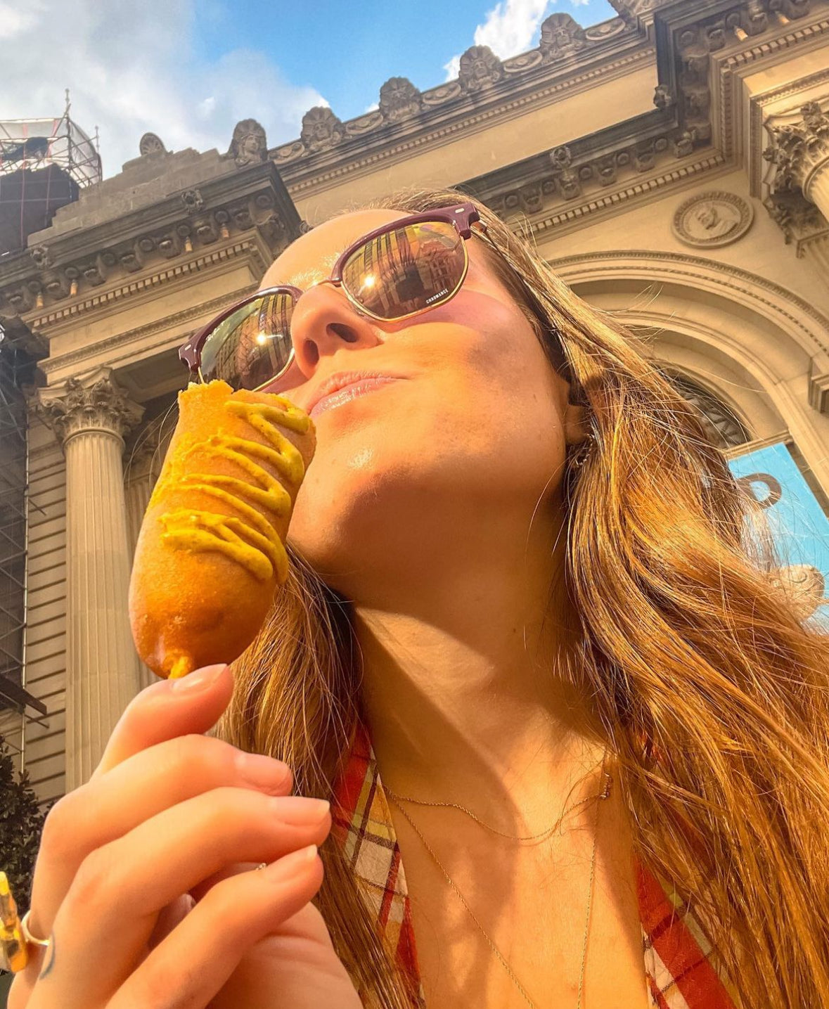 Elegant woman wearing luxurious fine jewelry from Always, A. eating a corndog in the streets of NYC